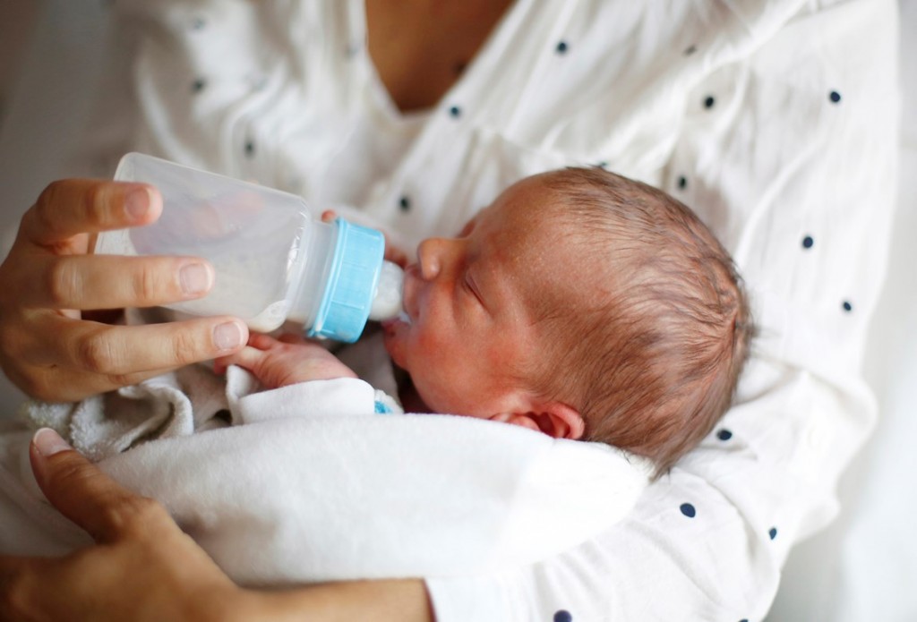 младенец пьет смесь из бутылочки