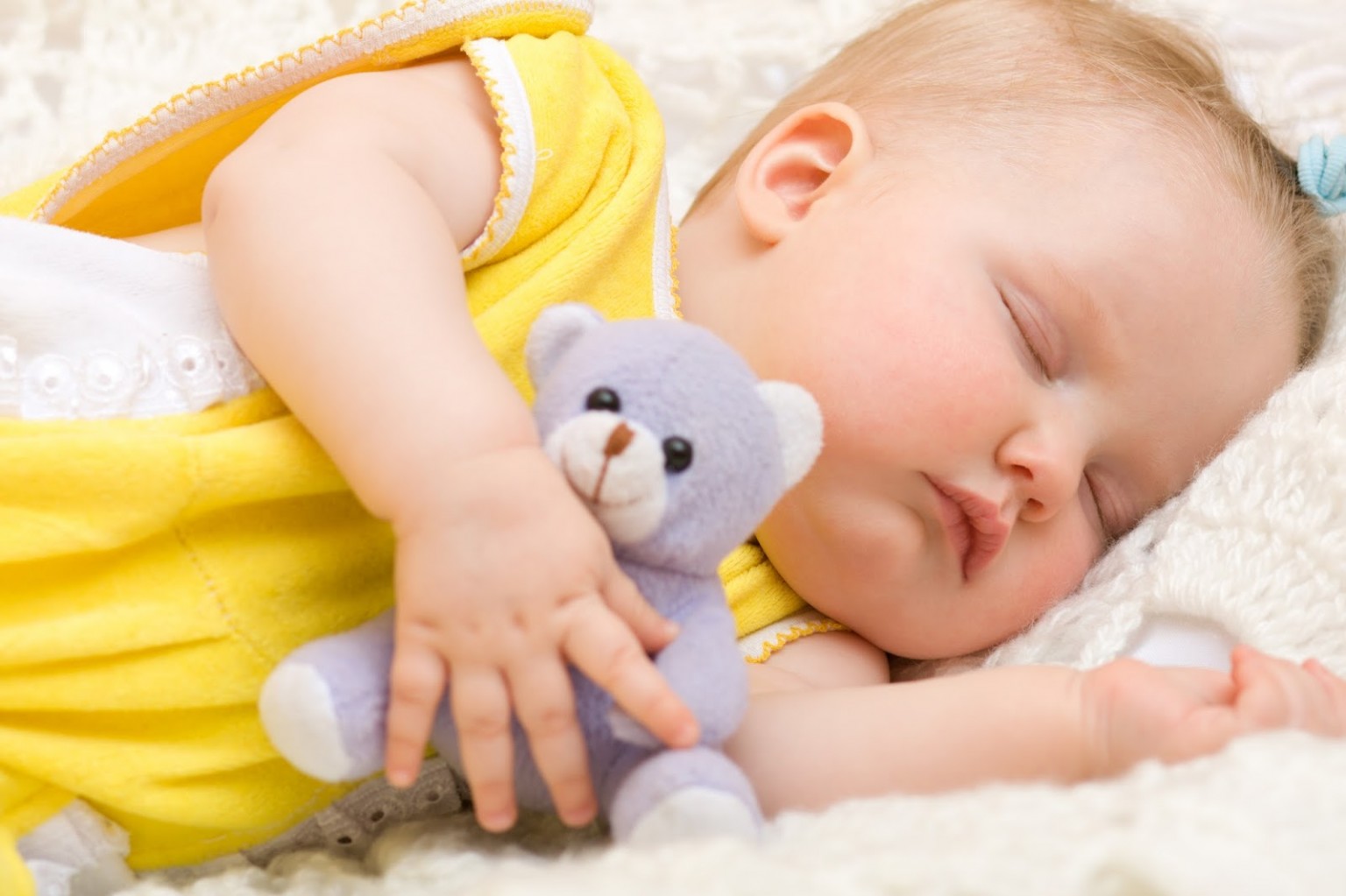 малыш спит на боку с игрушкой в руке