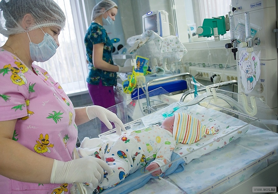 две акушерки рядом с новорожденными детьми в отделении