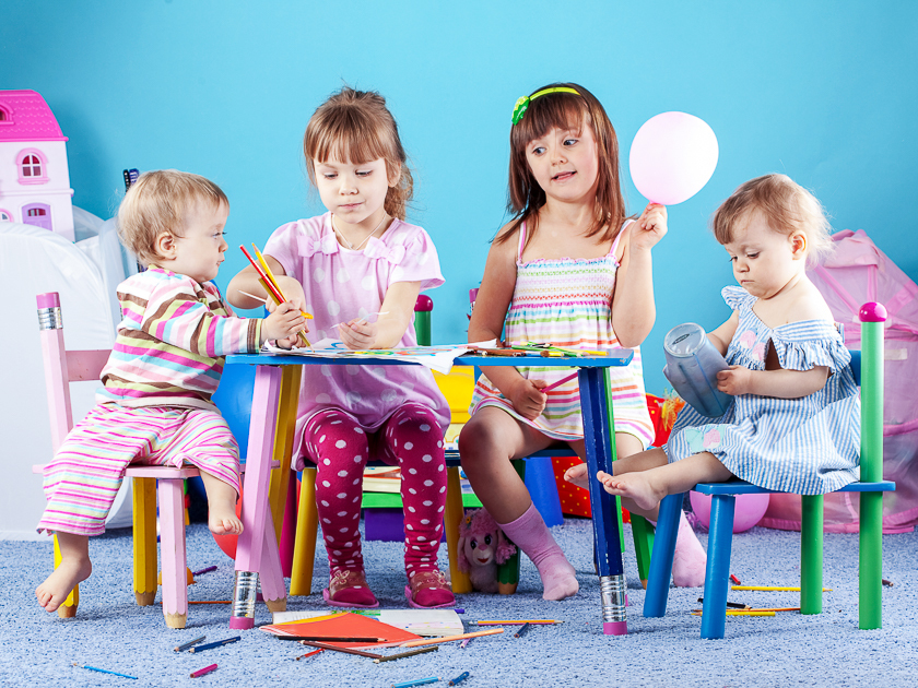 четыре ребенка играют в игры за столом